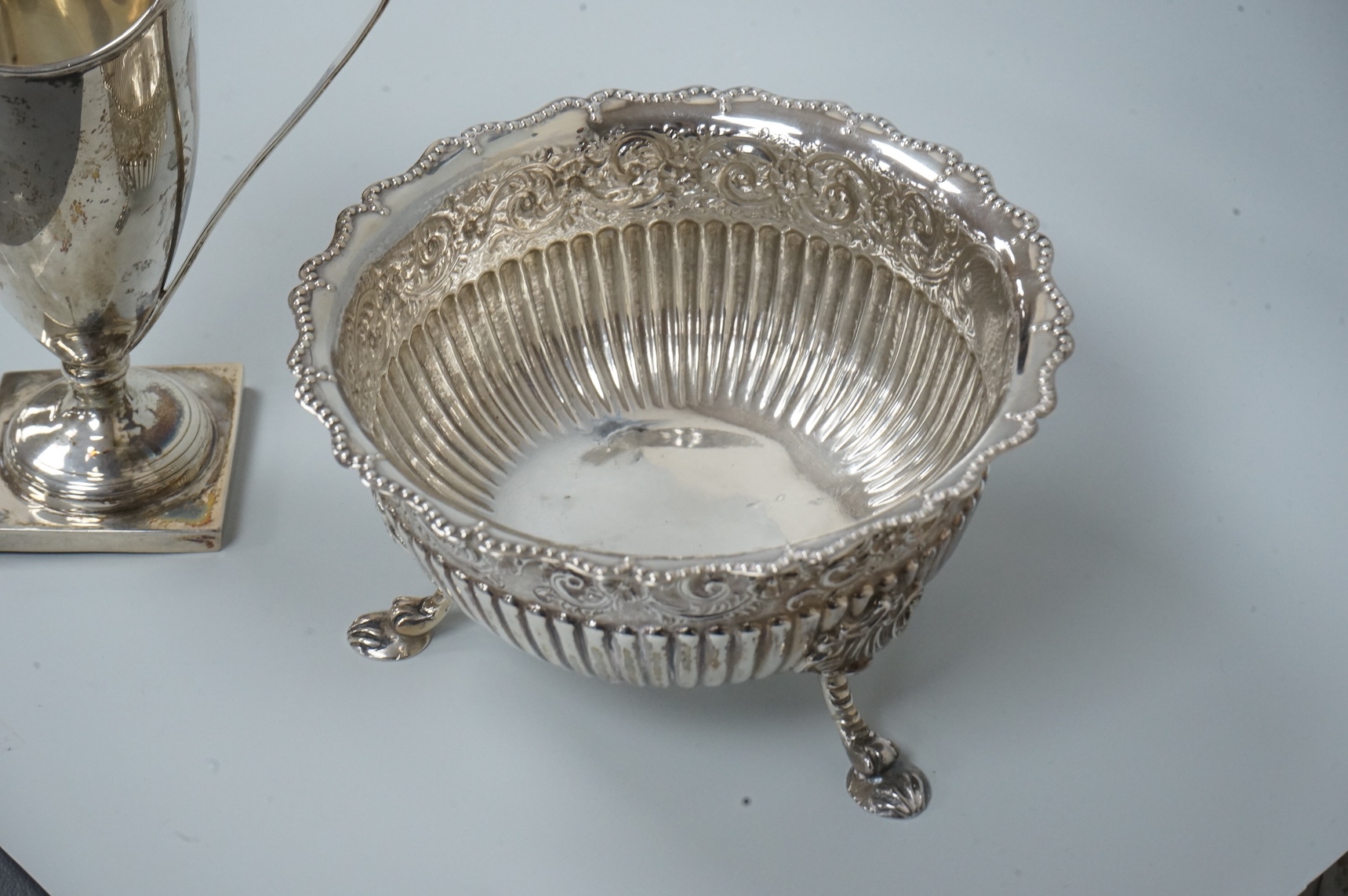 A late Victorian silver sugar basin, by Robert Harper, London, 1879, diameter 13.2cm, together with an Edwardian silver helmet shaped cream jug, Saunders & Shepherd, Chester, 1905, 15cm, 9.1oz.